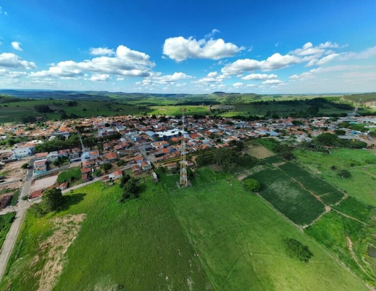 Vista aérea de cidade do interior cercada por plantações, ilustrando comparação entre regiões